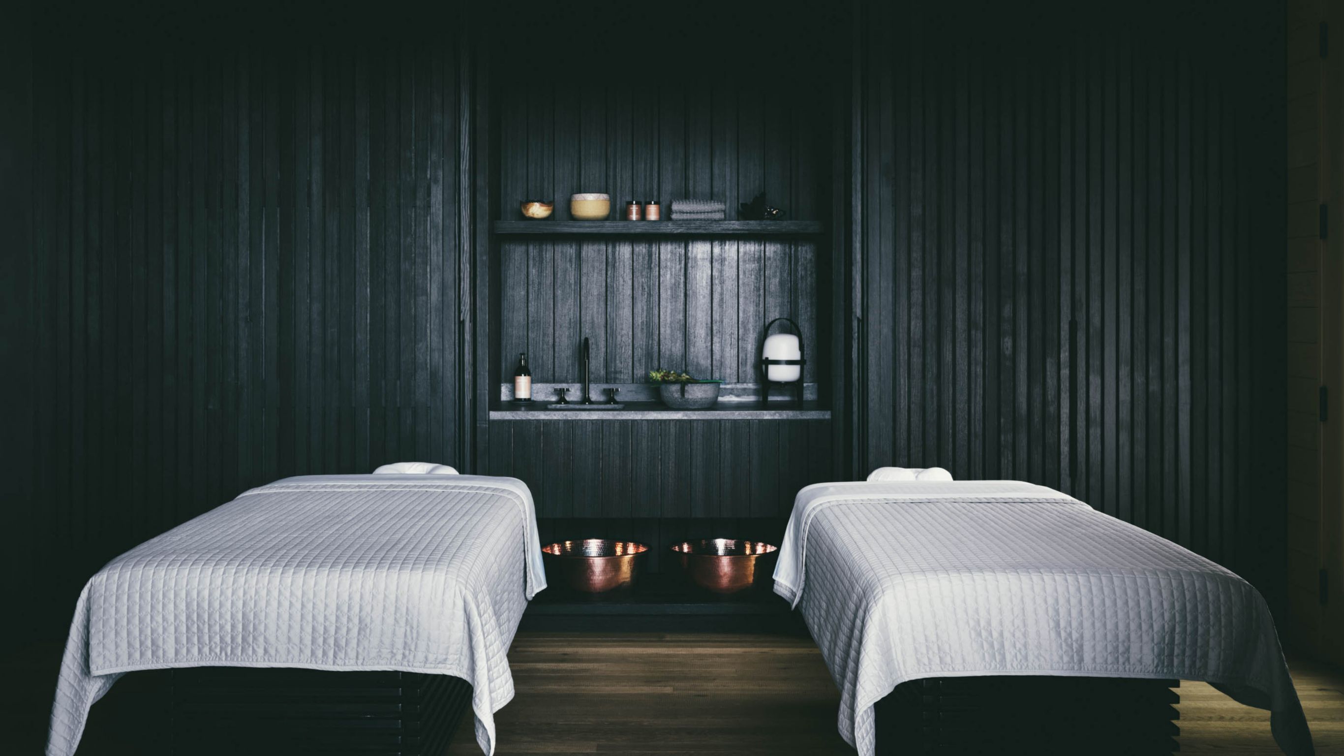 A Hawaiian spa room with two massage tables covered in white sheets.